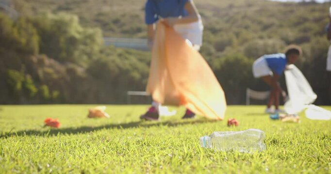 Picking up trash, girls cleaning school field, promoting environmental awareness
