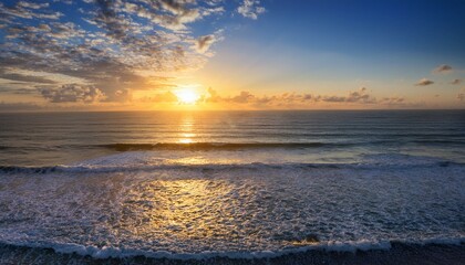 Obraz premium serene ocean view at sunrise with gentle waves and soft clouds reflecting warm light