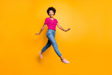 Obraz premium Full body photo of funny funky cheerful lady jump go walk feel crazy have free time wear spring clothes sneakers isolated over yellow color background