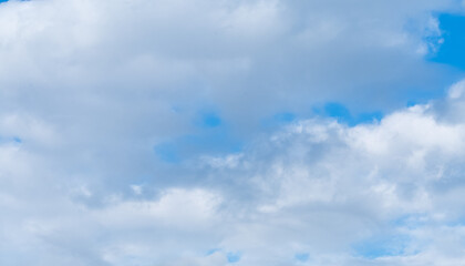A sky of different shades of blue with light and dark clouds.