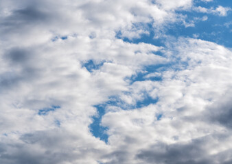 A sky of different shades of blue with light and dark clouds.