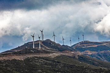 Wind Turbines on a Mountain Ridge Beneath a Dramatic Cloudy Sky, Crete