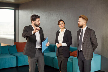 Businesspeople, confident business partners talking, debating in conversation, meet standing in modern office hall, motivated team discussing project, planning details, project colleagues, managers