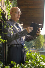 Man in Formal Attire shirt and tie Reading a Bible in a Lush Garden Setting wooden house outdoor	
