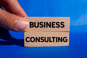 Business consulting message written on wooden blocks on blue background. Conceptual business consulting symbol. Copy space.
