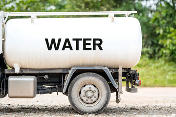 Water truck on gravel road. Clean water delivery to rural areas. Water sanitation, environmental preservation. Liquid transport. Water supply services.