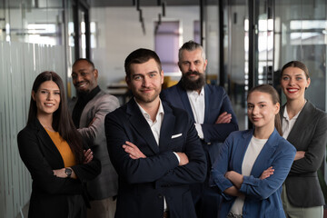 Obraz premium Confident business team standing together in a modern office, dressed in professional attire. Concept of leadership, teamwork, diversity, corporate success, and workplace collaboration