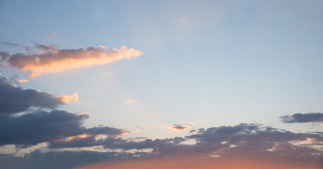 Obraz premium blue sky background with lighted cloud and pink shine from sundown, copy space right side