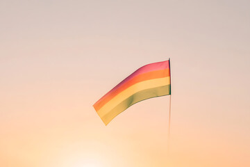 Rainbow Flag Against a Pastel Sky, Symbolizing Pride, Diversity, and Equality. Optimistic mood conveyed by the vibrant flag and soft sunrise colors.