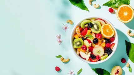 Colorful fruit salad with kiwi, oranges, berries, and nuts on light blue background