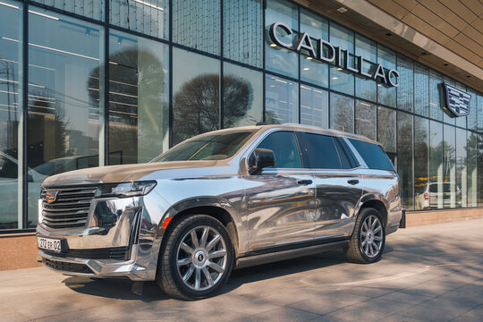 Almaty, Kazakhstan - February 21, 2025: A chrome Cadillac Escalade is parked outside a showroom