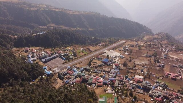 Aerial view of Lukla Airport and its dangerous runway, nestled in the Himalayas, showing surrounding villages and mountainous landscape