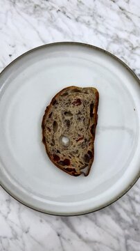 dropping delicious sourdough bread on plate
