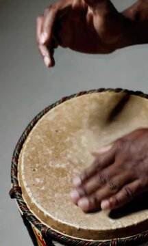 Rhythmic drumming hands on djembe: capturing organic percussive movements in closeup