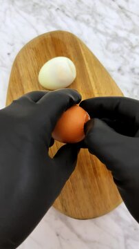 The act of peeling one hot hard boiled egg