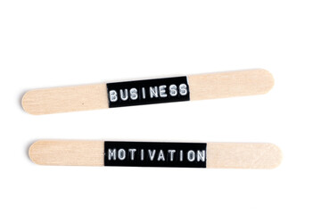 Wooden chopsticks isolated on white background, with the word business motivation.