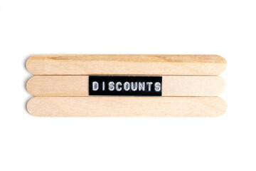 Word discounts on wooden popsicle sticks on white background.