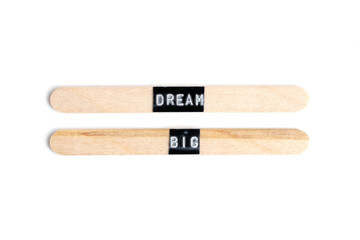 Wooden sticks with word dream big isolated on white background.