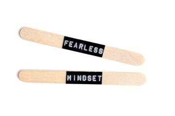Wooden ice cream sticks with inscription fearless mindset highlighted on white background.
