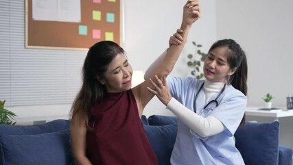 Physical therapist helping senior patient performing therapeutic arm exercises, targeting mobility and reducing discomfort in medical rehabilitation environment