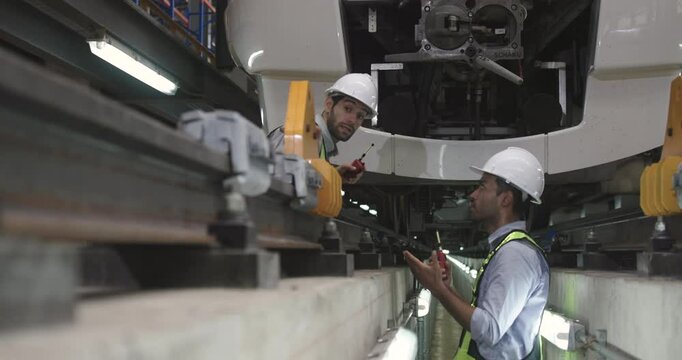 Specialist Rail engineers with a safety vest and PPE discussing train management and maintenance, electric train, rail transportation