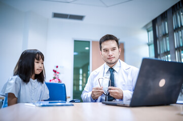 A male doctor is talking to the girl and asking about her health and giving advice.