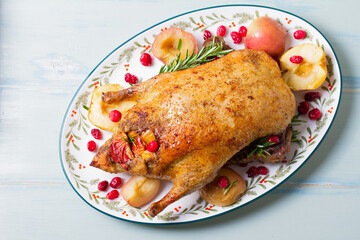 Roasted duck with apples and cranberries served with peas, red cabbage and potatoes. View from above, top view