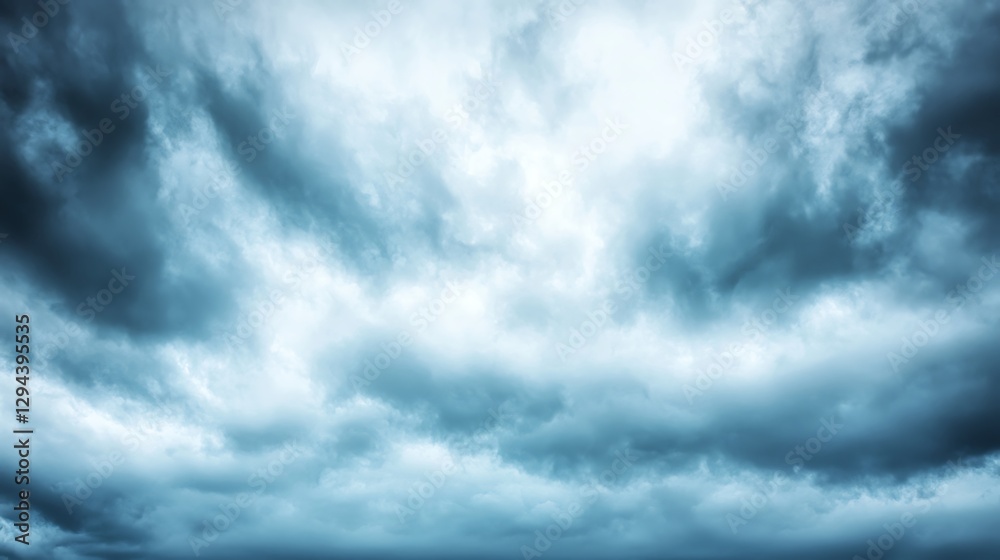 Wall mural an overcast sky with dark clouds scattered across, letting only a subtle light pass through, creatin