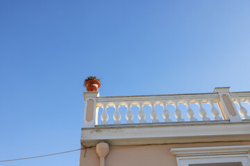 Plant pots on the corner of the roof of the house on a balustrade post