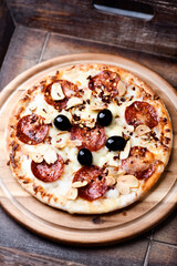 Pizza with chorizo ​​sausage, mozzarella cheese and black olives. Soft focus. Close up.