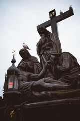 Statue auf der Karlsbrücke mit Tauben und einer Kerze