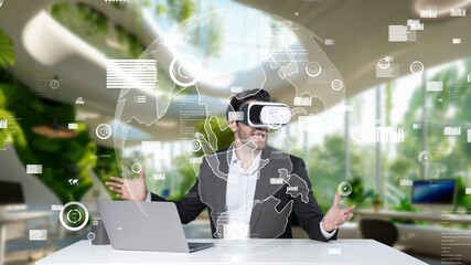 Manager sharing marketing idea while sitting at table with laptop while wearing virtual reality glasses. Investor checking at financial chart floating while connecting with global network. Apparatus.