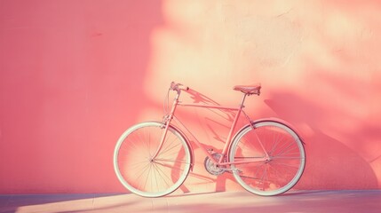 Fototapeta premium A retro-style bicycle mounted on a pastel pink wall, soft lighting and shadows