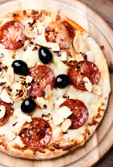 Pizza with chorizo ​​sausage, mozzarella cheese and black olives. Soft focus. Close up.