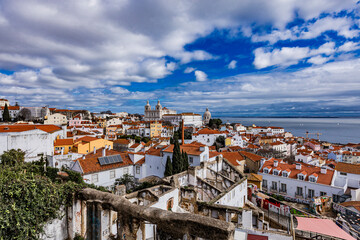 Fototapeta premium Stunning panoramic view of Lisbon with colorful rooftops and a vibrant sky over the Tagus River