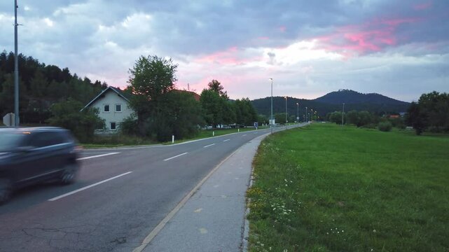Road leading to Lož from Stari Trg pri Ložu in the Lož valley, Slovenia, with a dramatic sky just after sunset