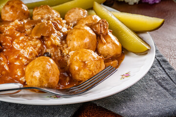 Chicken meatballs  and mushrooms gravy served with groats bulgur and pickled cucumber.