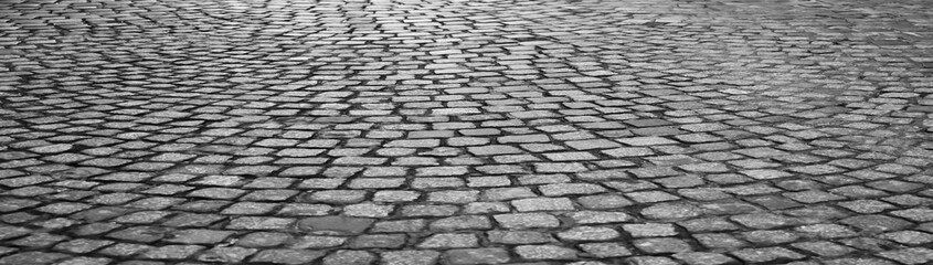 Stone pavement texture in perspective. Abstract background of old cobble stone pavement. historical cobblestone pavement. Old square cobble stone with green grass. paving perspective. Paving stone