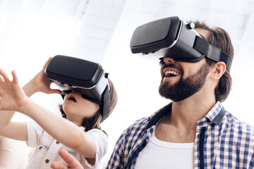 Father and son, using virtual reality glasses, play an interactive game.