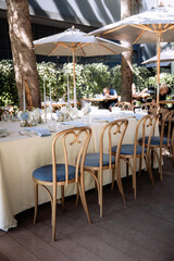Seating for guests at a table in a restaurant on a terrace in summer. Sunlight and dishes on the table luxury decor