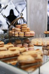 Desserts of macarons, pastries and sweets on a table for waiting guests. Macarons and sweets