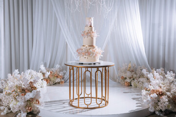 Luxurious white wedding cake decorated with fresh pink roses