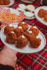 detail of a plate with a series of fried supplì filled with stringy mozzarella ready to be served and eaten during an evening party