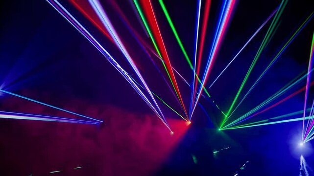 A dark environment illuminated by moving laser beams of various colors