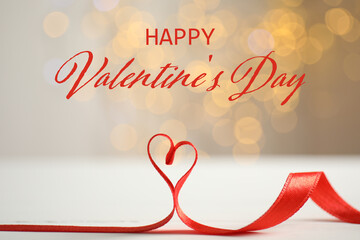 Happy Valentine's day card with heart made of ribbon on table