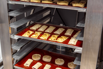 Raw puffs and buns on a rack. Not baked buns in the bakery