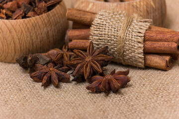 Star anise and cinnamon on burlap background, aromatic spices for cooking and baking