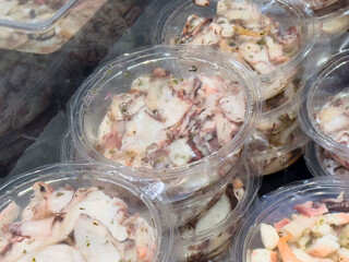 Freshly packaged octopus in transparent containers displayed for seafood enthusiasts
