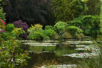 Green trees around pond with water lilies on a summer day in Monet's Garden in Giverny, France.