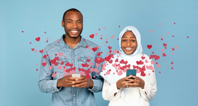 A couple is joyfully sharing affectionate messages through their smartphones on St. Valentines Day. Surrounded by floating hearts, they embrace the spirit of love and connection.